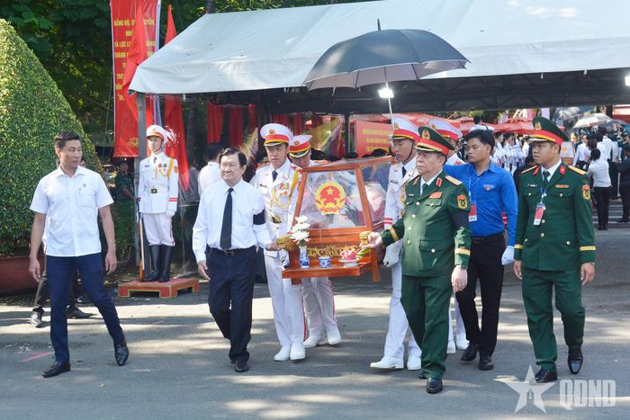Nguyên Chủ tịch nước Trương Tấn Sang và Đại tướng Nguyễn Trọng Nghĩa thành kính đưa quách hài cốt liệt sĩ lên xe về nơi an táng.