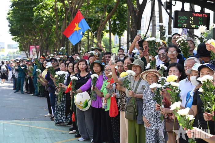 Đông đảo người dân TP Hồ Chí Minh thành kính tiễn đưa các Anh hùng liệt sĩ với cành hoa trắng trên tay.