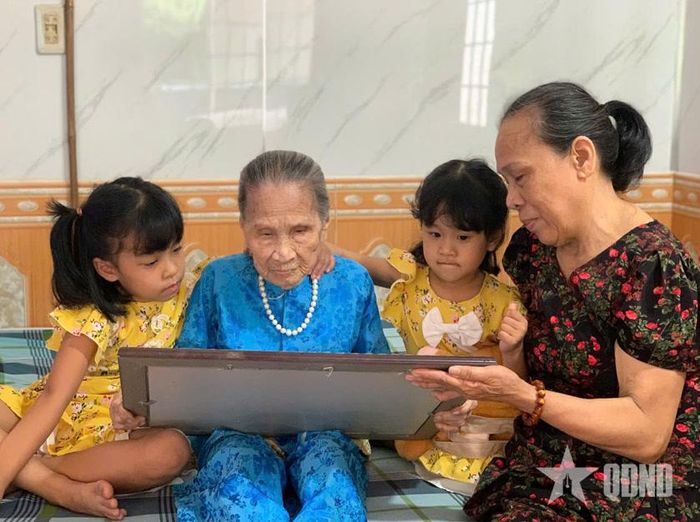 Bà mẹ Việt Nam anh hùng Lê Thị Sô cùng các cháu bên tấm Bằng Tổ quốc ghi công của liệt sĩ Võ Dĩnh.