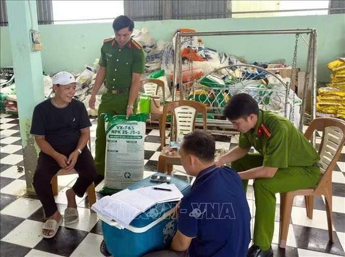 Lực lượng chức năng làm việc với đối tượng Hứa Văn Chọn (áo đen). Ảnh: TTXVN