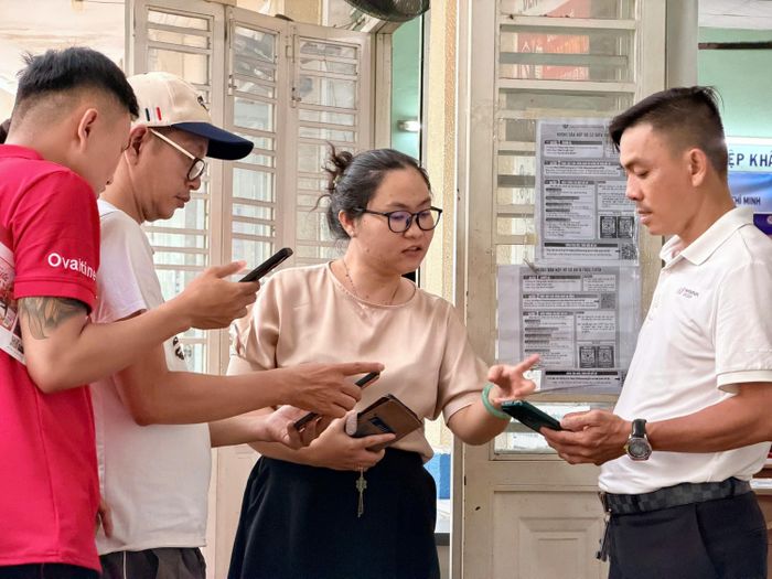 Nhân viên Trung tâm Dịch vụ việc làm TPHCM hướng dẫn thực hiện thủ tục bảo hiểm thất nghiệp trực tuyến tại số 249 Tôn Đản, phường Khánh Hội, TPHCM. Ảnh: HOÀNG HÙNG