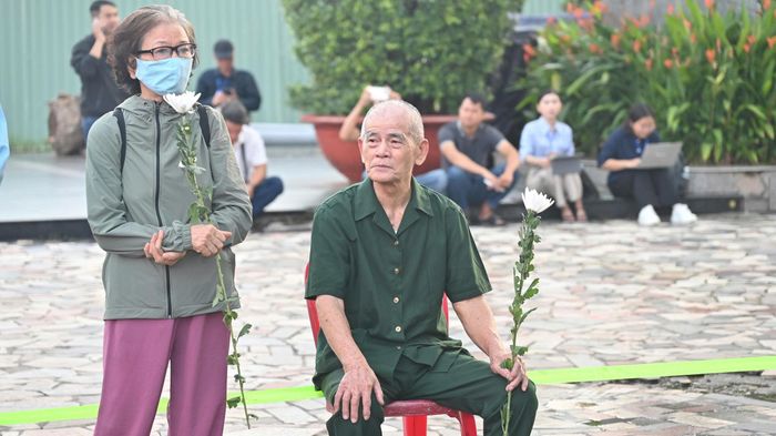  Cựu chiến binh Triệu Lẫy cùng vợ mang hoa trắng đến Công viên Lê Thị Riêng từ sáng sớm, tưởng nhớ đồng đội. Ảnh: MẠNH THẮNG 