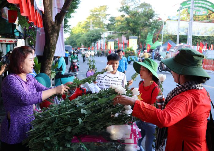  Gia đình chị Thu Trang (phường Phú Thạnh, TPHCM) mang hơn 700 nhành hoa cúc trắng tặng người dân quanh Công viên Lê Thị Riêng. Ảnh: HOÀNG TRIỀU 