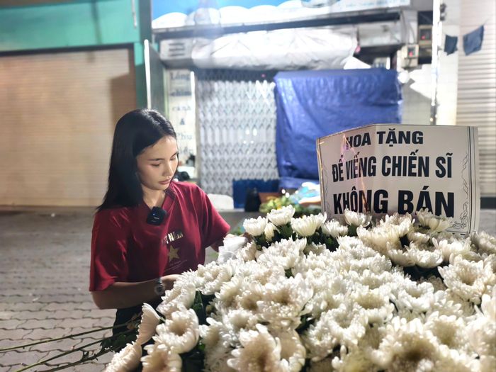  Chị Phan Thị Châu Lan cùng người thân, bạn bè chuẩn bị hoa tươi tặng người dân đến viếng các liệt sĩ. Ảnh: NGUYỄN TÂN 