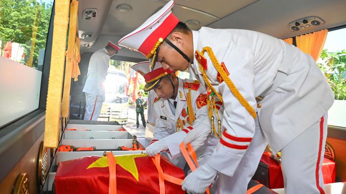  Nghi thức đưa hài cốt các liệt sĩ về nơi an nghỉ. Ảnh: MẠNH THẮNG 