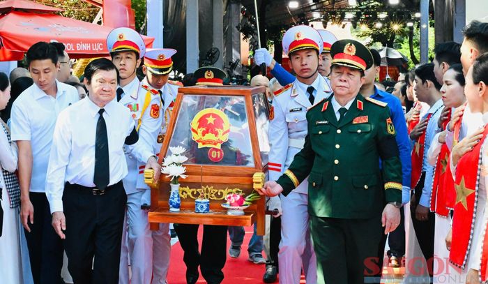  Đại tướng Nguyễn Trọng Nghĩa và nguyên Chủ tịch nước Trương Tấn Sang khiêng giá khiêng hài cốt liệt sĩ lên xe để di chuyển đến Nghĩa trang Liệt sĩ TPHCM 