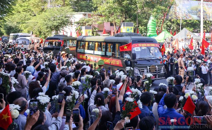  Người dân cùng những đoá hoa trắng đứng bên đường tiễn biệt các liệt sĩ 