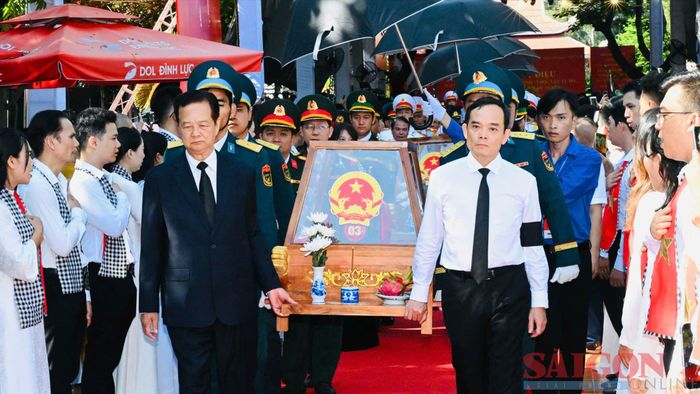  Nguyên Thủ tướng Nguyễn Tấn Dũng cùng Bí thư Thành ủy TPHCM Trần Lưu Quang khiêng giá khiêng hài cốt liệt sĩ lên xe để di chuyển đến Nghĩa trang Liệt sĩ TPHCM 