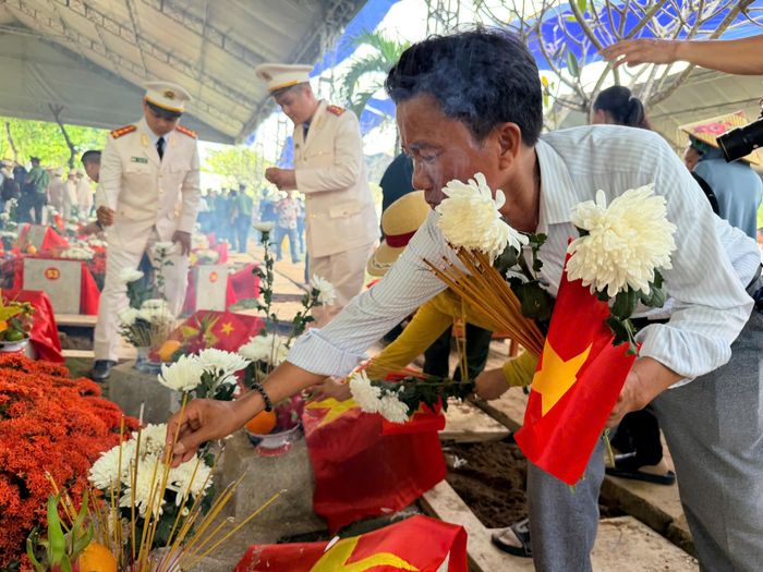  Người dân mang những nhành hoa trắng đến nghĩa trang, bày tỏ lòng biết ơn các Anh hùng liệt sĩ vừa được an táng. Ảnh: HOÀNG HÙNG 