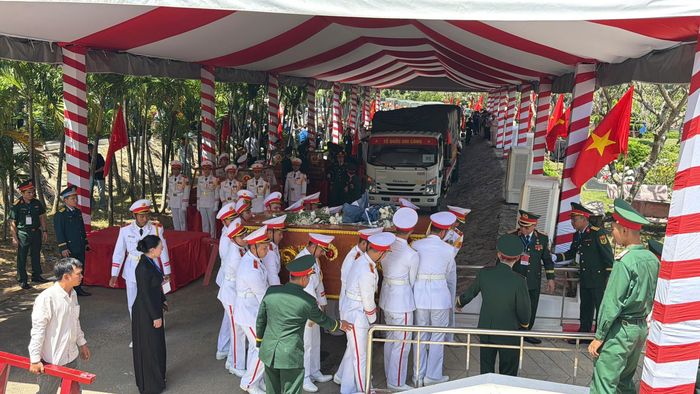  Quan tài tập thể chứa hài cốt 33 liệt sĩ được đưa về nghĩa trang trong đợt di quan thứ hai. Ảnh: HOÀNG HÙNG 