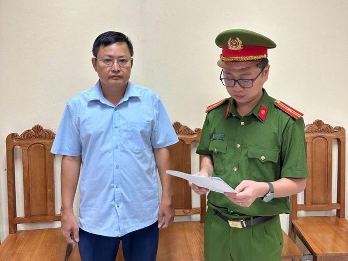 Cơ quan Cảnh sát điều tra tống đạt quyết định khởi tố bị can, lệnh cấm đi khỏi nơi cư trú đối với Hoàng Mạnh Dũng. Ảnh: CÔNG AN CUNG CẤP