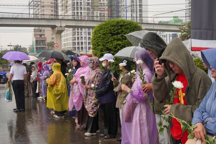 Người dân đội mưa thành kính tri ân các Anh hùng liệt sĩ, chiều 14-10. Ảnh: Quốc Toàn 