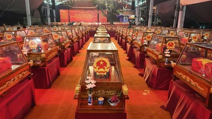 Mỗi bộ hài cốt liệt sĩ được đặt trong tiểu quách phủ quốc kỳ, bên ngoài là quách kính, phía trước là hoa cúc trắng. (Ảnh: Nhóm PV)