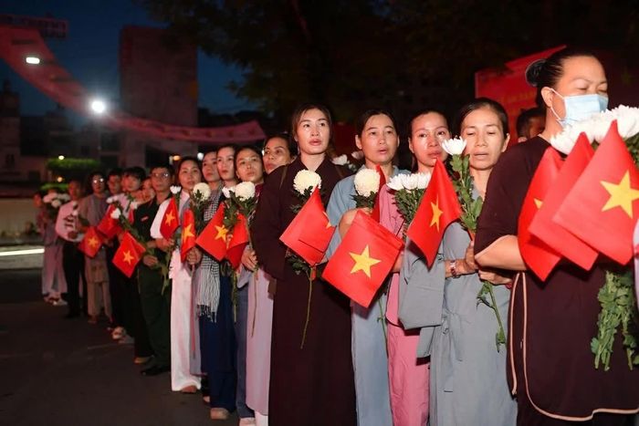 Bà Thanh Hường, 45 tuổi, ở khu vực quận Bình Tân cũ, rời nhà từ 3h cho kịp giờ lễ. “Gia đình tôi cũng có người hy sinh trong chiến tranh, nên tôi muốn đến cùng mọi người tiễn đưa các chú, các bác đã nằm xuống năm xưa”, bà nói. (Ảnh: Nhóm PV)