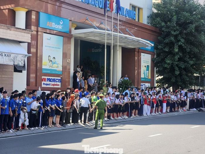 Học sinh Trường THPT Năng khiếu Thể dục Thể thao TPHCM đứng dọc đường Điện Biên Phủ, thành kính tiễn đưa các anh hùng liệt sĩ về nơi an nghỉ. Ảnh: Huế Xuân