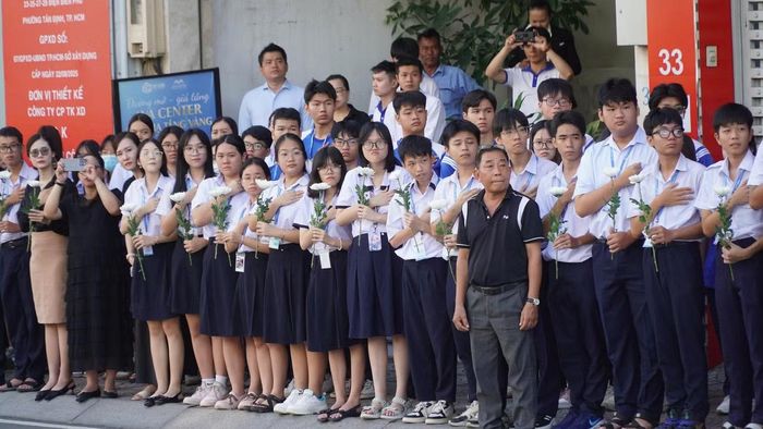 Học sinh, sinh viên và người dân đứng dọc 2 bên đường Điện Biên Phủ, tay cầm hoa cúc trắng, đứng trang nghiêm tiễn đưa đoàn xe đi qua. Ảnh: Huế Xuân