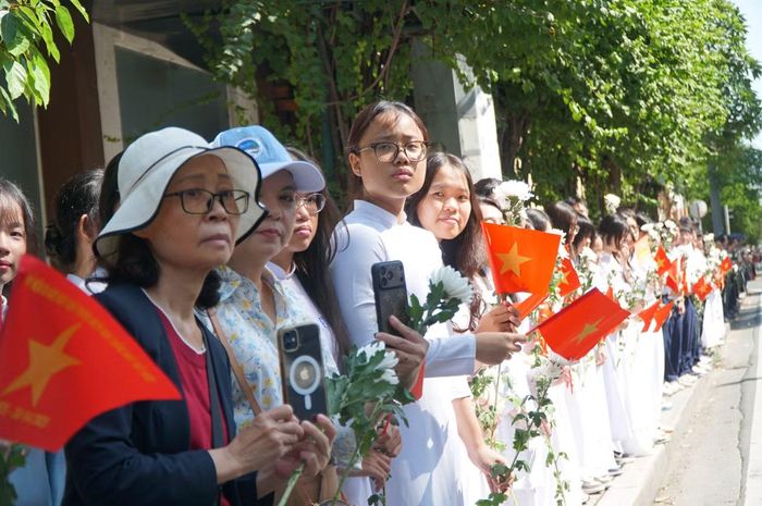 Học sinh Trường THPT Marie Curie đứng dọc 2 bên đường tiễn đưa các anh hùng liệt sĩ. Ảnh: Anh Nhàn