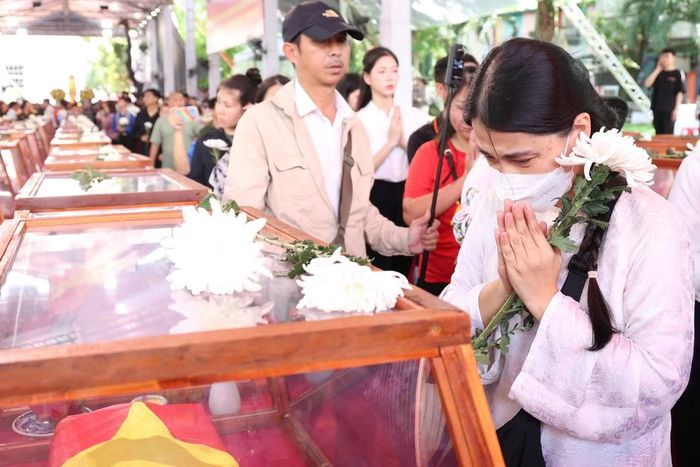 Người dân bật khóc bên hài cốt liệt sĩ. Nhiều người nhẹ nhàng đặt nhành hoa trắng lên quách để tiễn đưa những người anh hùng về nơi an nghỉ cuối cùng.