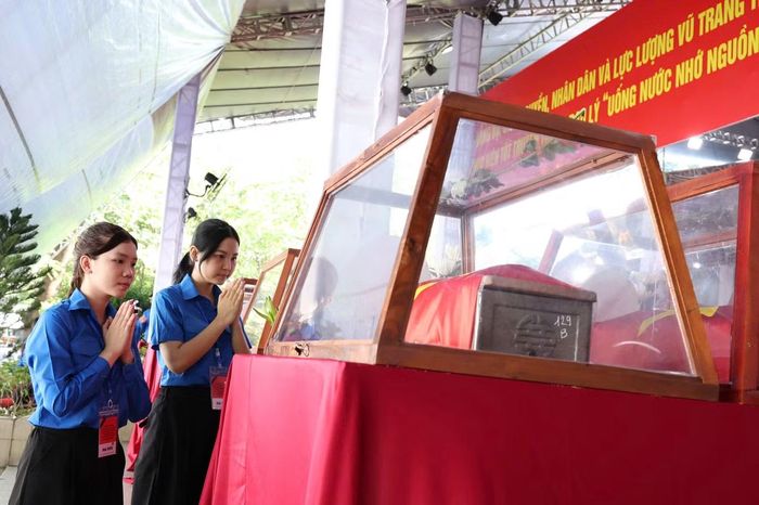 Nữ đoàn viên chắp tay thành kính trước hài cốt của anh hùng liệt sĩ, sáng 14/10.