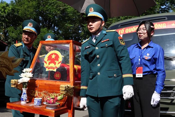 Theo từng đợt di quách hài cốt liệt sĩ ra xe để chuyển đến nơi an táng, thanh niên song hành hỗ trợ che nắng trong quá trình di chuyển, đảm bảo sự tôn nghiêm, thành kính.