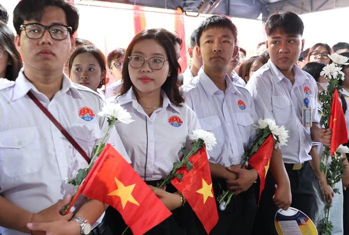Sinh viên Học viện Cán bộ TPHCM cầm cờ Tổ quốc và nhành hoa trắng tiễn đưa các Anh hùng liệt sĩ, tại Công viên văn hóa Lê Thị Riêng.