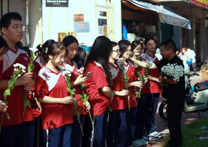 Nhiều nhóm thiện nguyện phát hoa miễn phí cho người dân, học sinh để tiễn đưa các anh hùng liệt sĩ về đất mẹ.
