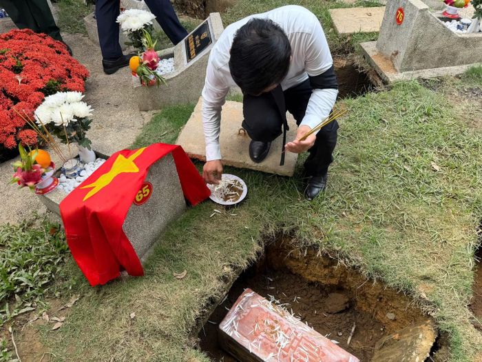 Các đại biểu tham dự thực hiện nghi thức trải hoa trắng và cát tiễn đưa các liệt sĩ về nơi an nghỉ cuối cùng.