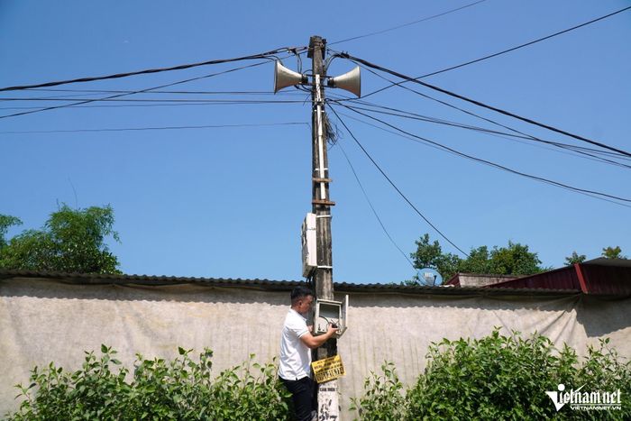 Đang dự họp ở thôn, nhưng nghe gọi báo loa truyền thanh hỏng, ông Toàn lập tức ra ngoài, trèo lên cột điện để sửa chữa. Ảnh: Lê Dương