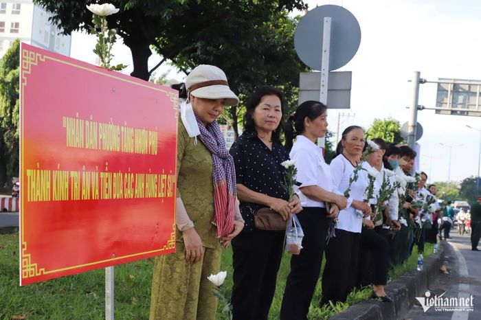 Người dân TPHCM xếp hàng trang nghiêm dọc tuyến đường Võ Nguyên Giáp chờ đón đoàn xe. Ảnh: Tuấn Kiệt
