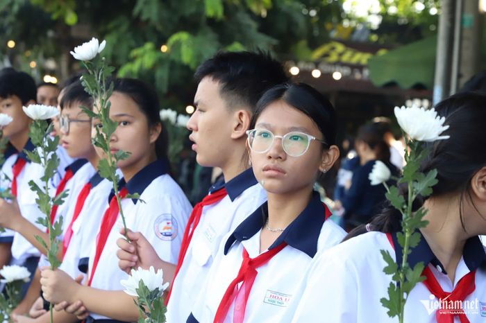 Các em học sinh nâng niu những nhành cúc trắng, thành kính tưởng niệm và tri ân các anh hùng liệt sĩ. Ảnh: Tuấn Kiệt