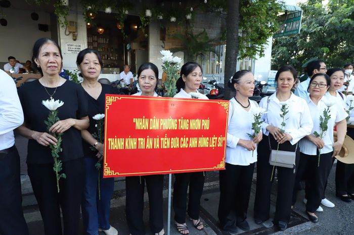 Các cựu chiến binh và lực lượng vũ trang nghiêm trang đứng dọc các nút giao thông, chờ đón đoàn xe đi qua. Ảnh: Tuấn Kiệt