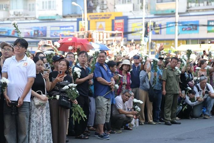  Trong dòng người đang ngóng đợi, những bông hoa trên tay không đơn thuần là vật phẩm tưởng niệm mà còn gửi gắm lòng biết ơn và niềm tự hào đối với những người đã ngã xuống vì đất nước.