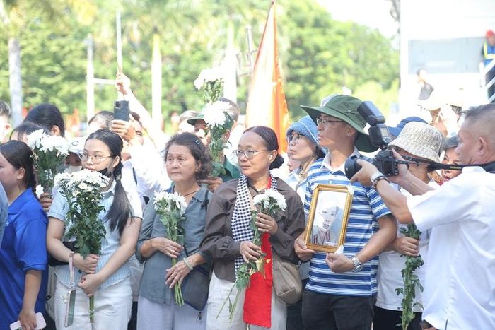   Nhiều người cầm trên tay những bông cúc trắng, mắt hướng về đoàn xe chở các Anh hùng liệt sĩ đã hy sinh vì độc lập, tự do của Tổ quốc. 