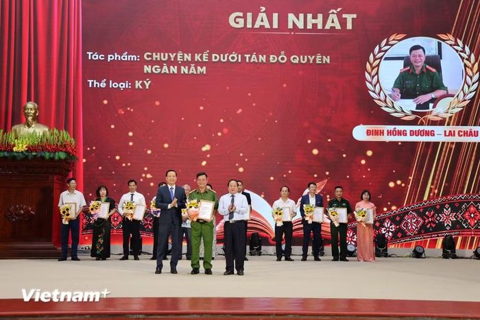 : Ông Tống Thanh Hải, Phó Chủ tịch Thường trực UBND tỉnh và ông Lê Đức Dục, Trưởng Ban Tuyên giáo Tỉnh ủy, Trưởng Ban Tổ chức Cuộc thi trao Giải Nhất ở thể loại ký cho tác giả Đinh Hồng Dương (Công an tỉnh) với tác phẩm “Chuyện kể dưới tán Đỗ Quyên ngàn năm". (Nguồn: Vietnam+)