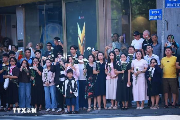 Đông đảo nhân dân Thành phố Hồ Chí Minh với nhành hoa trắng trên tay đưa tiễn hài cốt các Anh hùng liệt sỹ về Nghĩa trang liệt sỹ Thành phố Hồ Chí Minh. (Ảnh: Dương Giang/TTXVN)