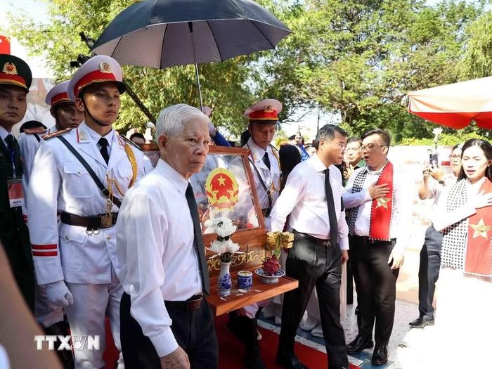 Lãnh đạo, nguyên lãnh đạo Đảng, Nhà nước thực hiện nghi thức di quan, đưa hài cốt liệt sỹ lên xe về an táng tại Nghĩa trang Liệt sỹ Thành phố. (Ảnh: Xuân Khu/TTXVN)