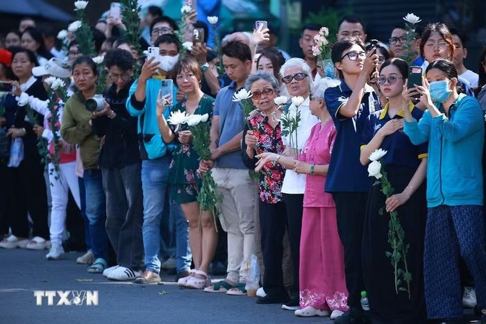 Đông đảo nhân dân Thành phố Hồ Chí Minh với nhành hoa trắng trên tay đưa tiễn hài cốt các Anh hùng liệt sỹ về Nghĩa trang liệt sỹ Thành phố Hồ Chí Minh. (Ảnh: Dương Giang/TTXVN)