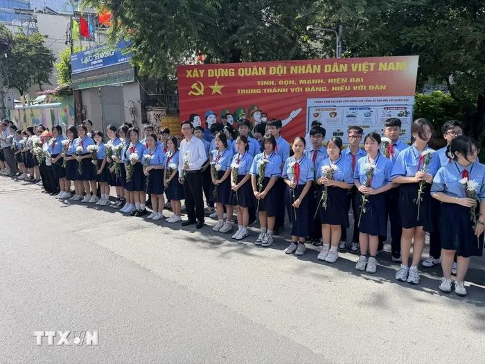 Đông đảo các tầng lớp nhân dân đứng dọc hai bên đường tiễn đưa, tưởng nhớ các Anh hùng liệt sỹ được quy tập tại Công viên Lê Thị Riêng về nơi an táng. (Ảnh: Trung Tuyến/TTXVN)
