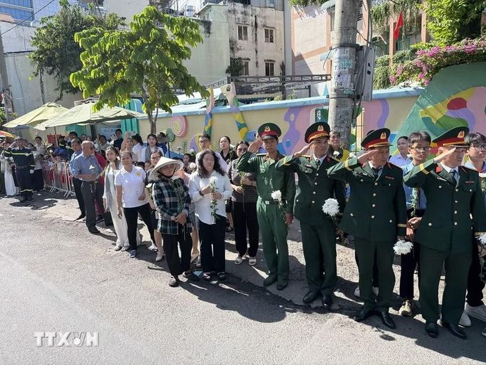 Đông đảo các tầng lớp nhân dân đứng dọc hai bên đường tiễn đưa, tưởng nhớ các Anh hùng liệt sỹ được quy tập tại Công viên Lê Thị Riêng về nơi an táng. (Ảnh: Trung Tuyến/TTXVN)