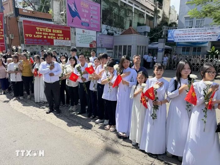 Đông đảo các tầng lớp nhân dân đứng dọc hai bên đường tiễn đưa, tưởng nhớ các Anh hùng liệt sỹ được quy tập tại Công viên Lê Thị Riêng về nơi an táng. (Ảnh: Trung Tuyến/TTXVN)