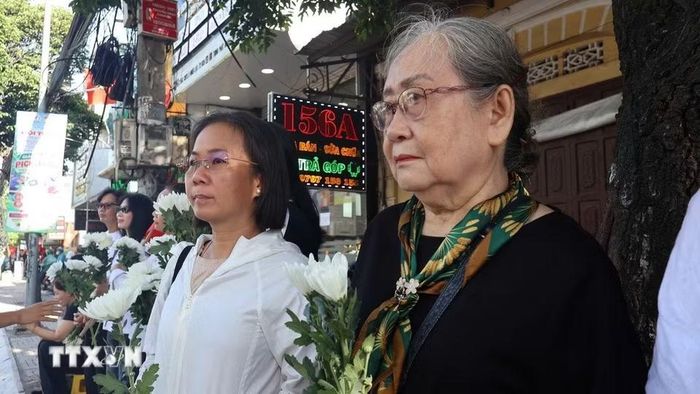 Đông đảo các tầng lớp nhân dân đứng dọc hai bên đường tiễn đưa, tưởng nhớ các Anh hùng liệt sỹ được quy tập tại Công viên Lê Thị Riêng về nơi an táng. (Ảnh: Trung Tuyến/TTXVN)