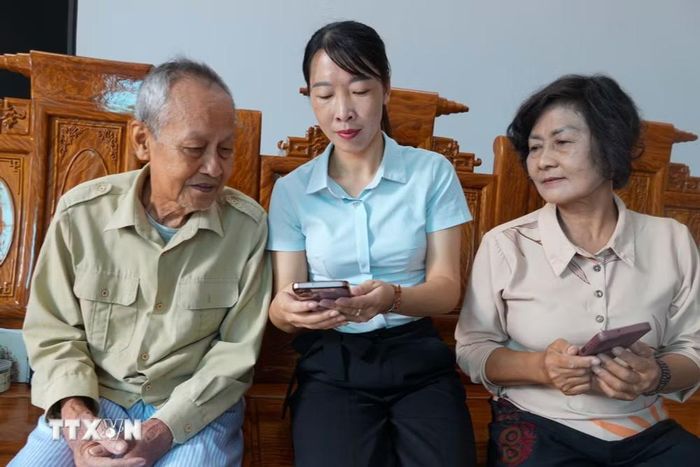 Trưởng bản Duyên Long, xã Thanh An (Điện Biên) Vũ Thị Hồng Uyên thường xuyên xuống cơ sở nắm tình hình, tuyên truyền, vận động người dân sử dụng công nghệ số trên điện thoại thông minh. (Ảnh: Phan Quân/TTXVN)