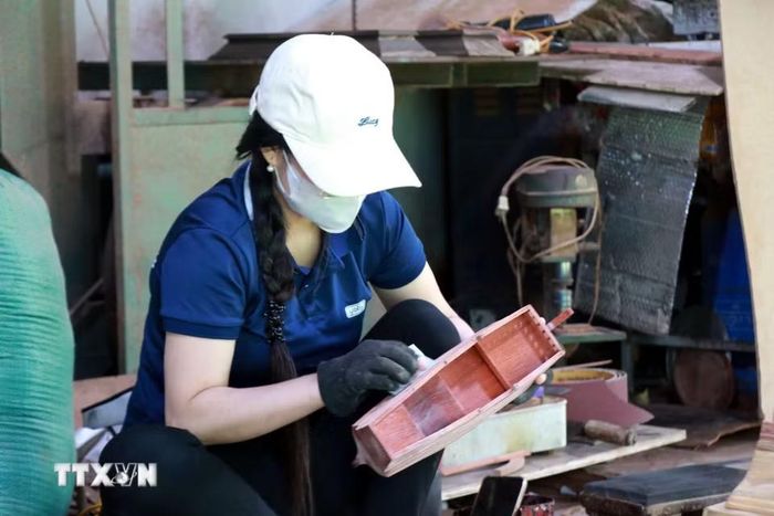 Công nhân mài nhẵn thân thuyền. (Ảnh: Nguyễn Lành/TTXVN)