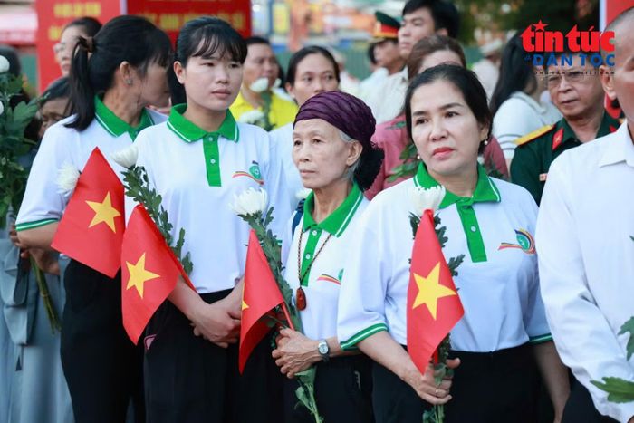 Những người cao tuổi mang theo hoa trắng, bày tỏ lòng thành kính đối với các liệt sĩ.