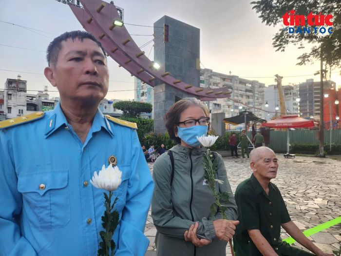 Bà Phạm Thị Minh Nguyệt đang đứng chờ tiễn biệt các liệt sĩ về nơi an nghỉ cuối cùng.