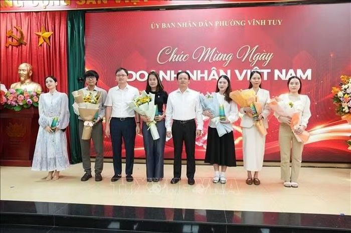 Lãnh đạo phường Vĩnh Tuy tặng hoa chúc mừng đại diện các doanh nghiệp nhân Ngày Doanh nhân Việt Nam.