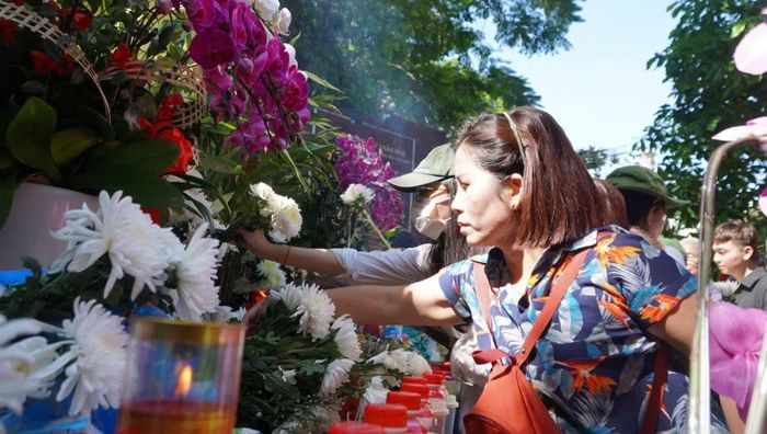 Đoàn xe đi ngang qua, người dân cũng tranh thủ gửi những bông hoa cúc trắng.