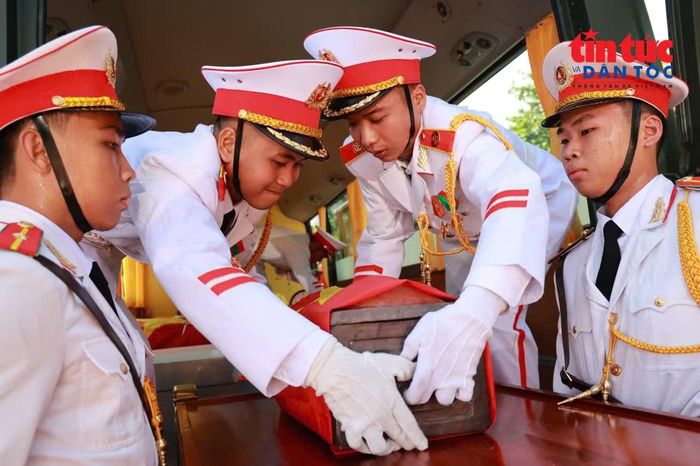 Đoàn xe đưa hài cốt liệt sĩ đi qua trong sự thành kính của người dân đứng dọc tuyến đường.