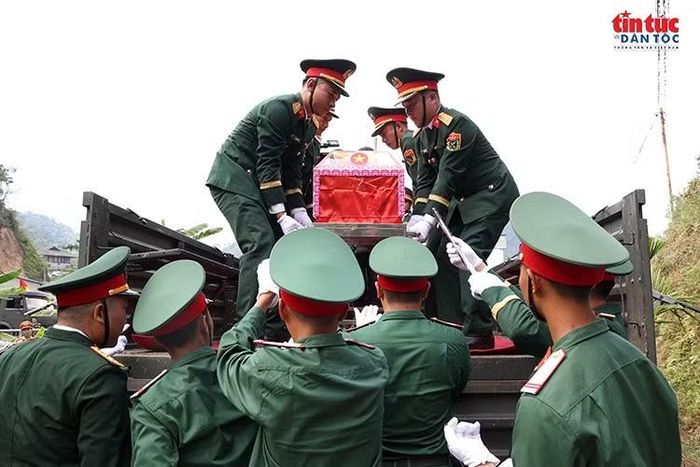 Cán bộ, chiến sĩ nâng đỡ, đưa từng quách đựng hài cốt liệt sĩ lên xe chuyên dụng với sự cẩn trọng, thành kính.
