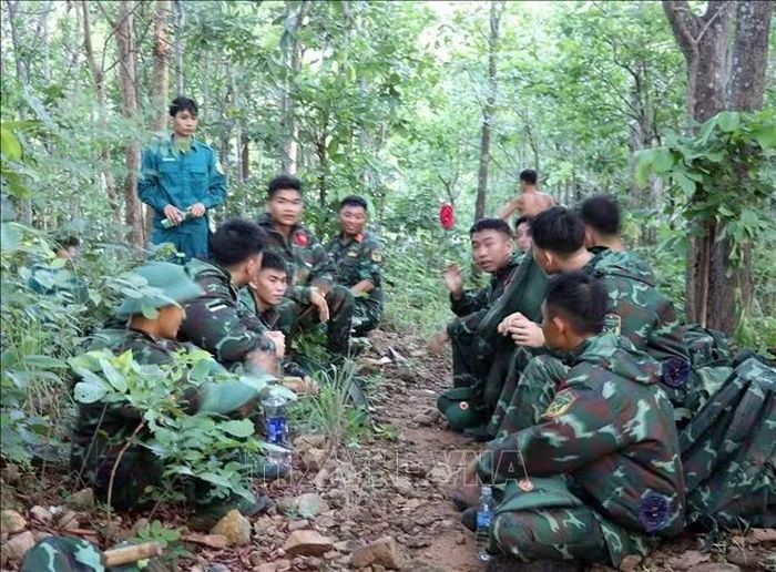 Các chiến sĩ nghỉ chân trước khi tiếp tục hành trình vượt núi để đến khu vực cất bốc hài cốt liệt sĩ.